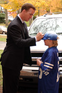 Peyton Manning signing a fan's hat