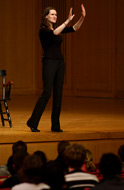 Liz Murray holding up her hands on stage during an Ubben Lecture