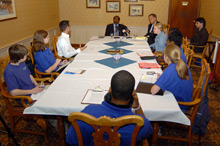 Paul Rusesabagina speaking to students at a table