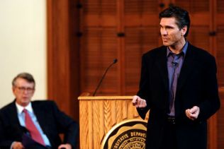 Jim Alling delivering an Ubben Lecture with Bob Bottoms in the background