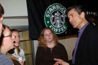 Jim Alling talking to students with Starbucks banner in the background
