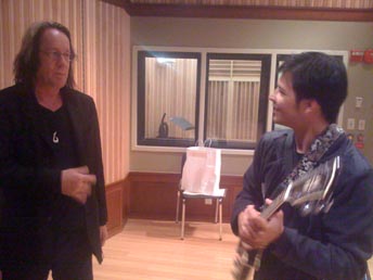 Todd Rundgren talking with Seth Tsui holding a guitar