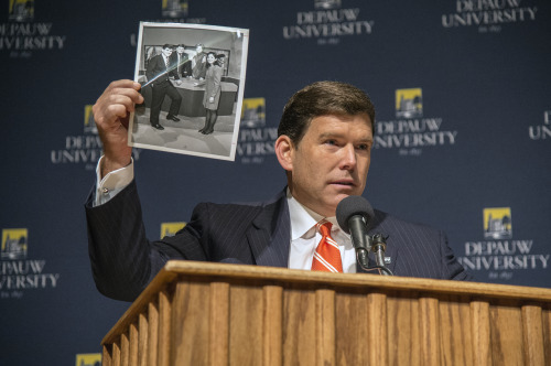 Bret Baier holding up a black and white photo during his Ubben Lecture
