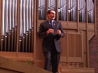 Mike Krzyzewski leaning against the pipes in Kresge Auditorium
